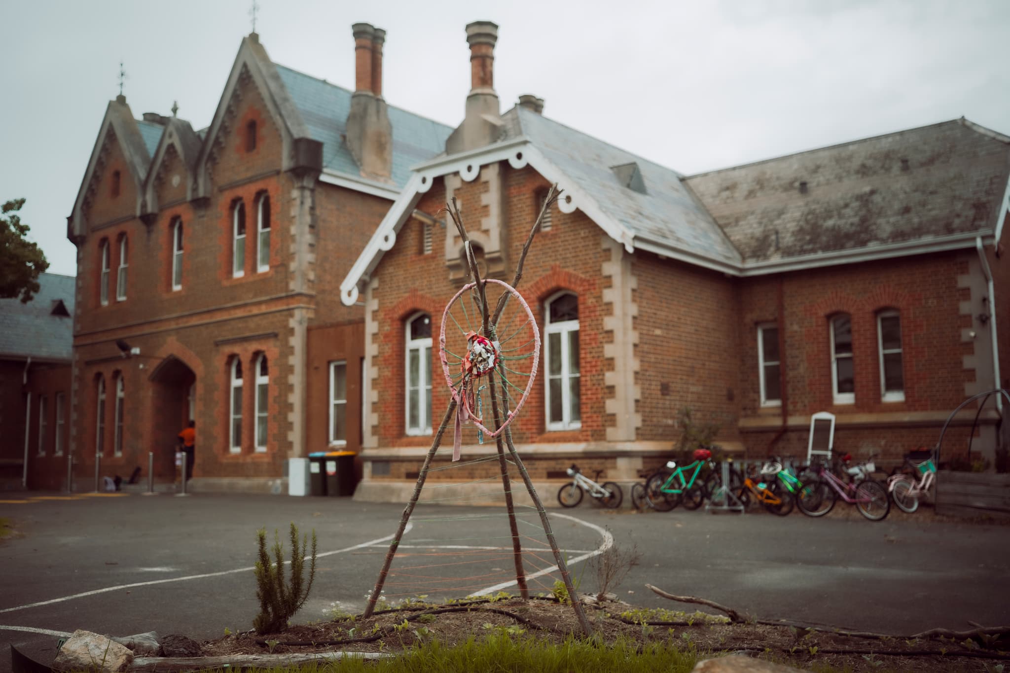 School entrance with garden weaving and childrens bicycles.