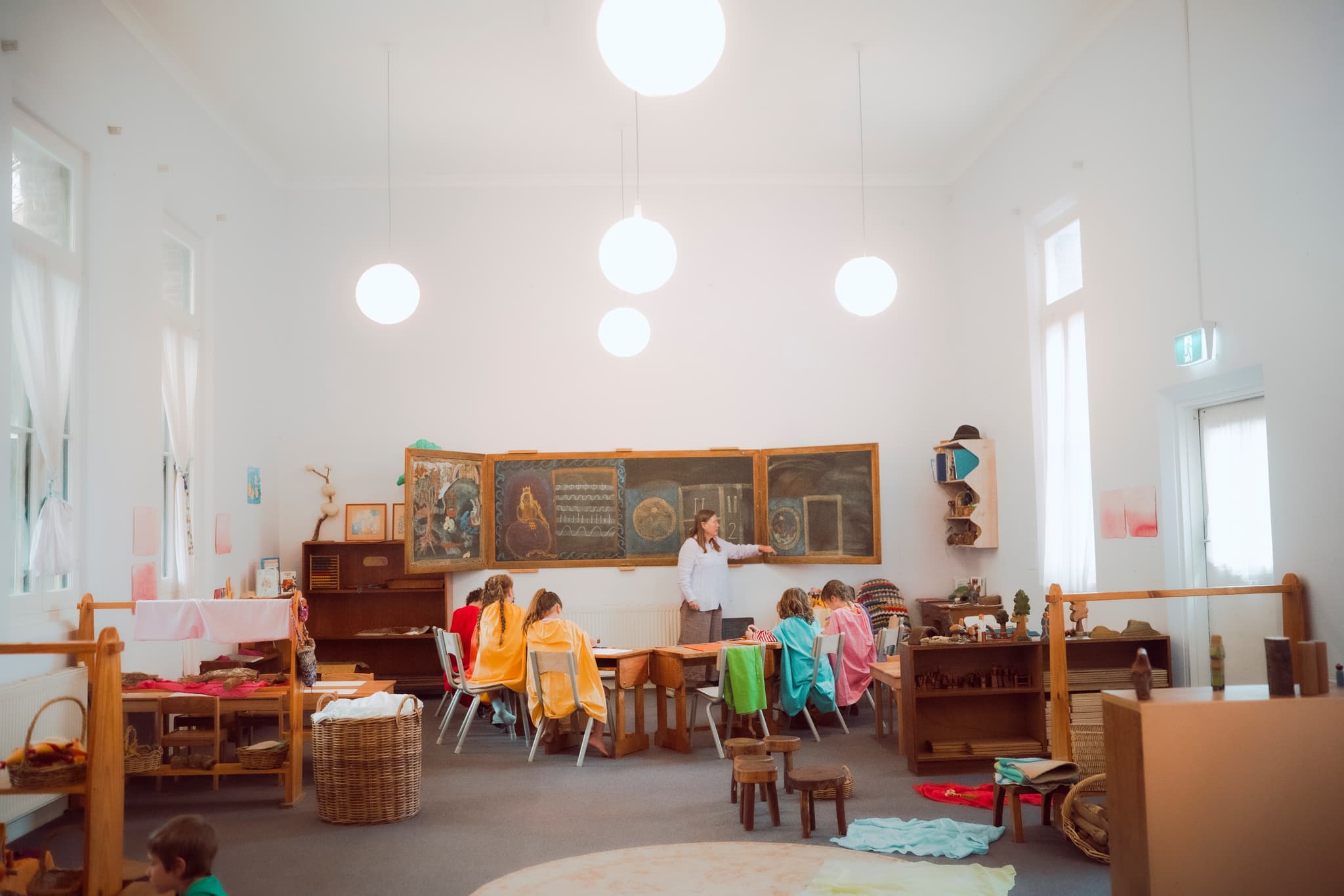 Primary classroom with illustrated chalkboard and children learning
