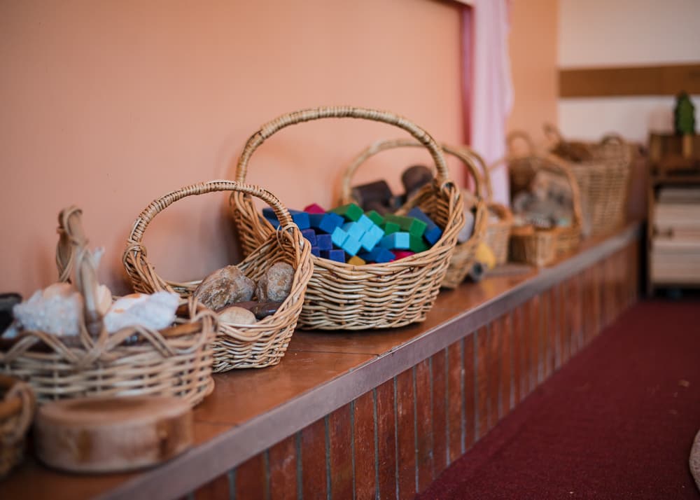 Kindergarten shelf with wooden toys, natural play materials, and a seasonal still life